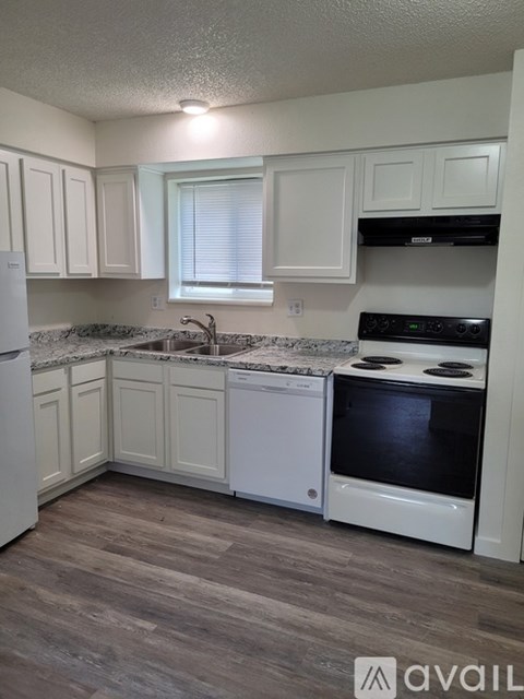 A kitchen with white cabinets and a granite countertop.