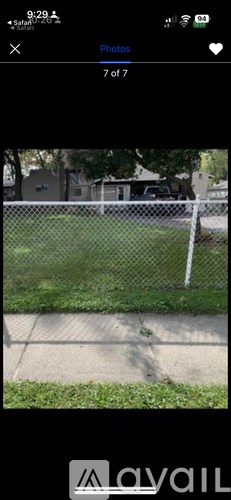 A photo gallery app with a photo of a fence and grass.