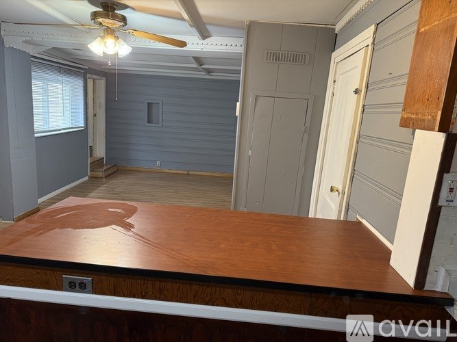 A room with a ceiling fan and a wooden table.