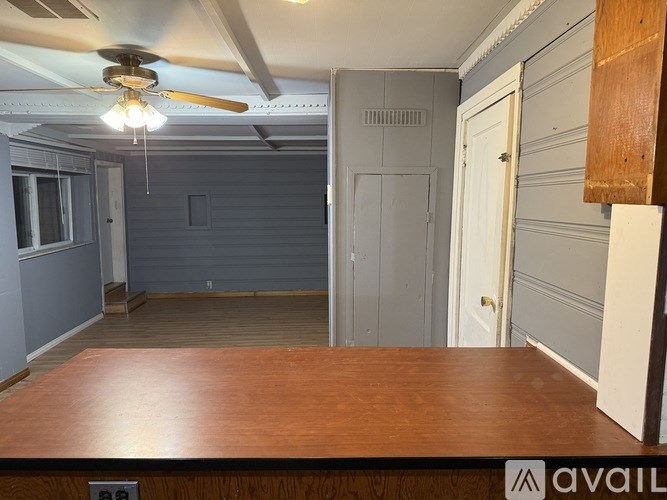 A room with a ceiling fan and a wooden table.