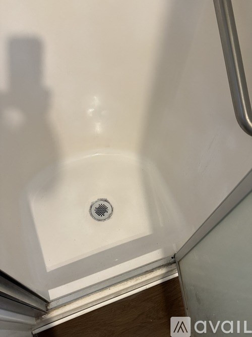 A white sink in a bathroom with a drain in the middle.