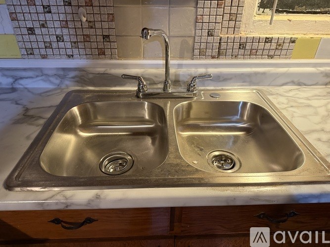 A double sink in a marble countertop with a silver faucet.