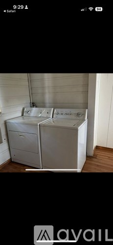 A white filing cabinet with two drawers is on a wooden floor.