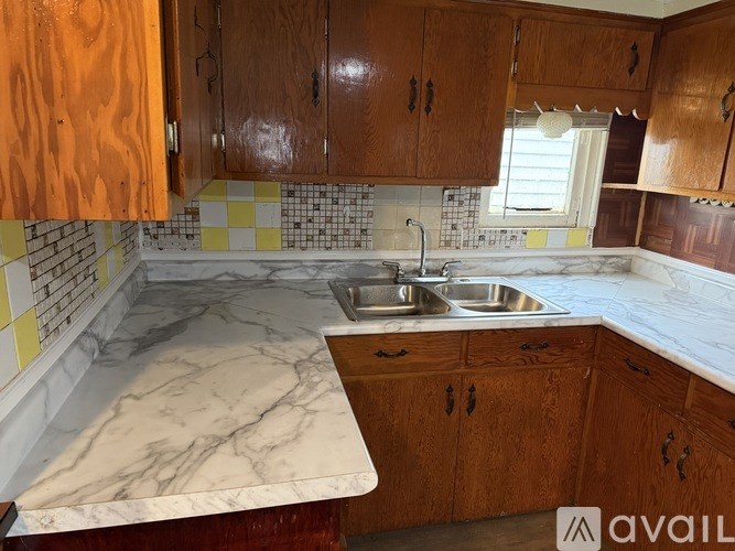 A kitchen with wooden cabinets and marble countertops.