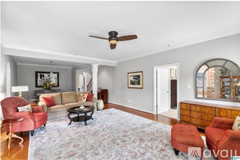 A living room with a red chair and a couch.