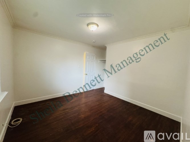 A room with a wooden floor and a text that says "Sheila Bennett Management".