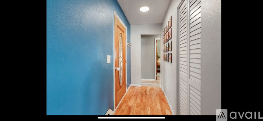 A hallway with a blue wall on the left and a white wall on the right.