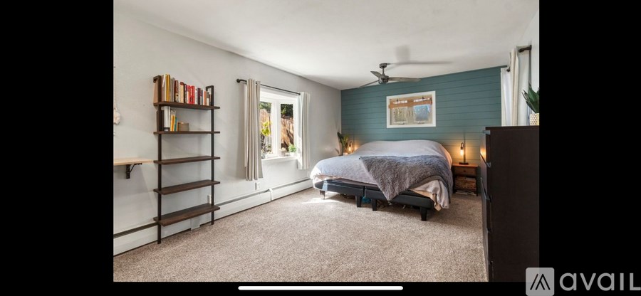 A bedroom with a bed, a ceiling fan, and a bookshelf.