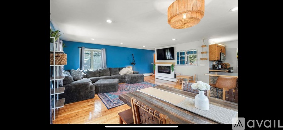 A living room with a grey couch and a wooden table.