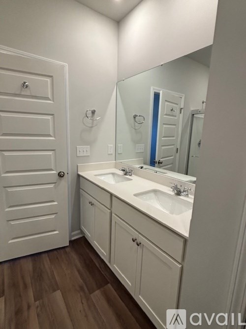 A bathroom with a white sink and a white door.