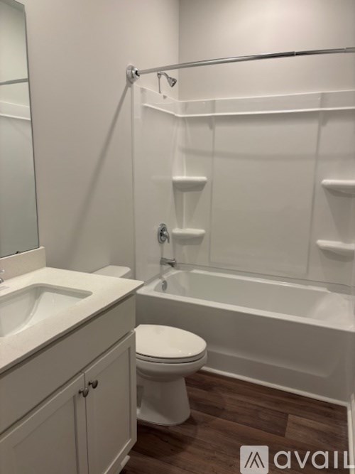 A white toilet is in a bathroom with a walk-in shower.