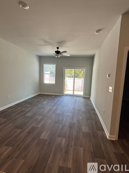 A room with wooden flooring and a ceiling fan.