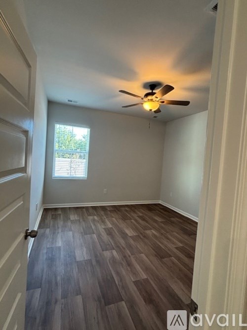 A room with a ceiling fan and a window.