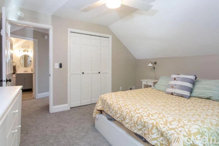 A bedroom with a bed, dresser, and mirror.
