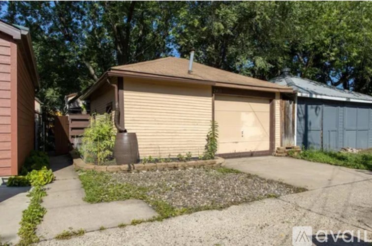 A house with a closed garage door and a small garden in front.