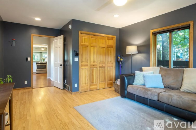 A living room with a brown couch and a wooden door.