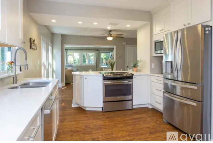 A kitchen with white cabinets and stainless steel appliances.