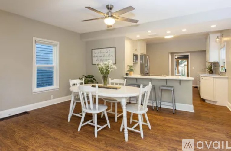 A dining room with a white table and chairs.