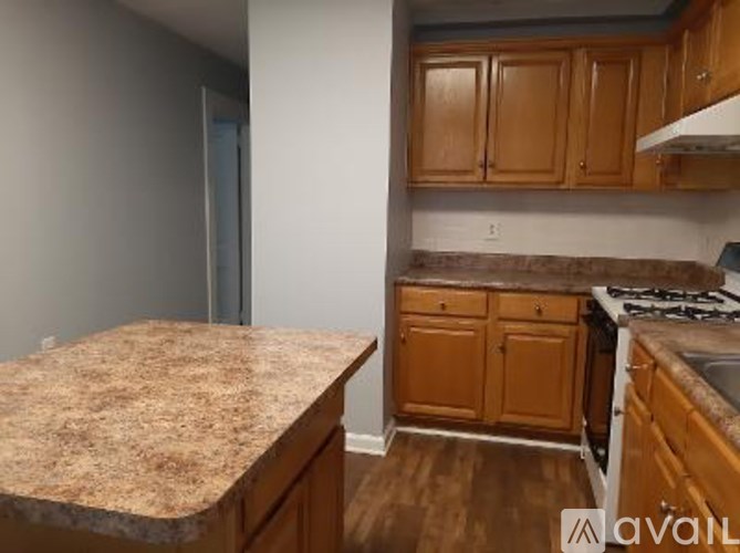 A kitchen with wooden cabinets and a granite countertop.