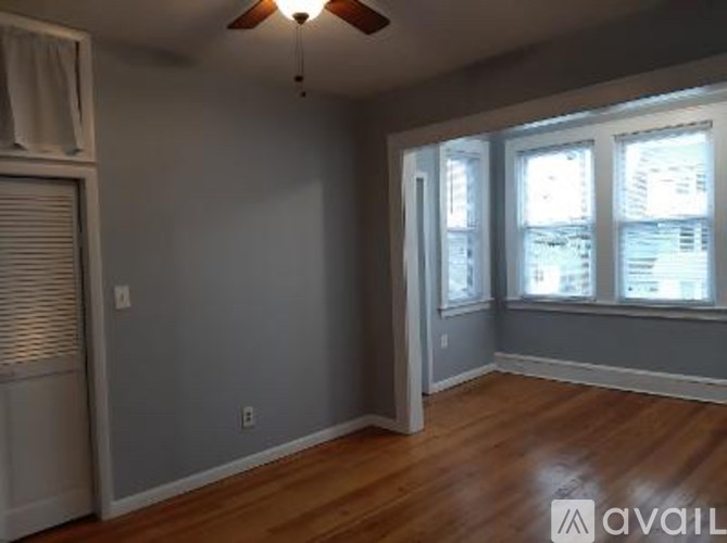 A room with a ceiling fan and a window with blinds.