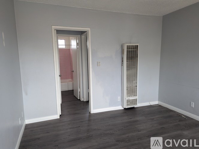 A room with a doorway leading to another room and a wall-mounted air conditioning unit.