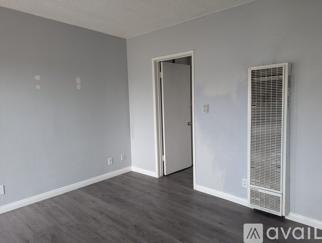 A room with a door and a wall-mounted air conditioning unit.