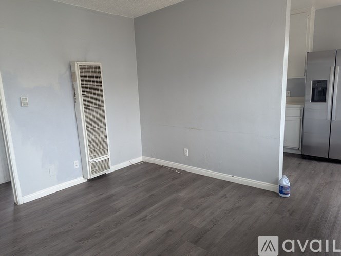 A room with a wooden floor and a wall-mounted air conditioner unit.