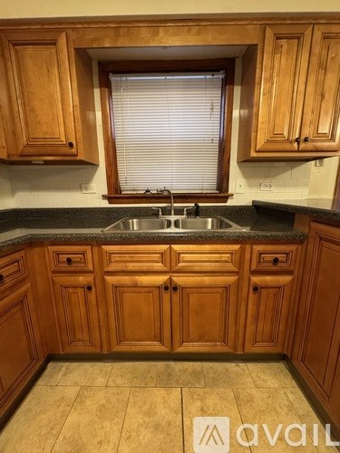 A kitchen with wooden cabinets and a black countertop.