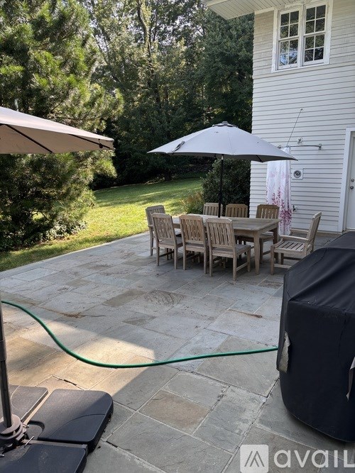 A patio with a table and chairs under an umbrella.