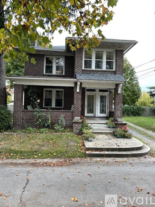 A two-story house with a front porch and a driveway.