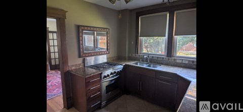 A kitchen with a stove top oven and a sink.