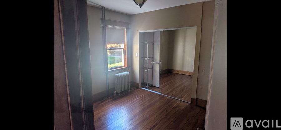 A room with wooden floors and a large mirror on the wall.