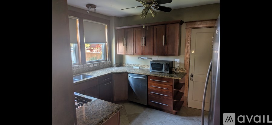 A kitchen with brown cabinets and a granite counter top.