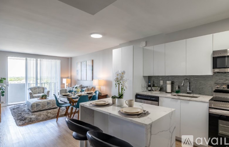 A modern kitchen with a dining table set for two.
