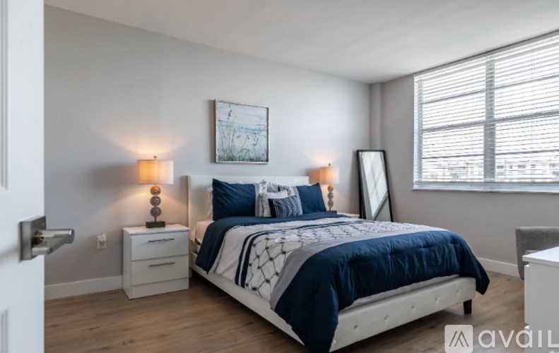 A bedroom with a bed, nightstands, and a window.