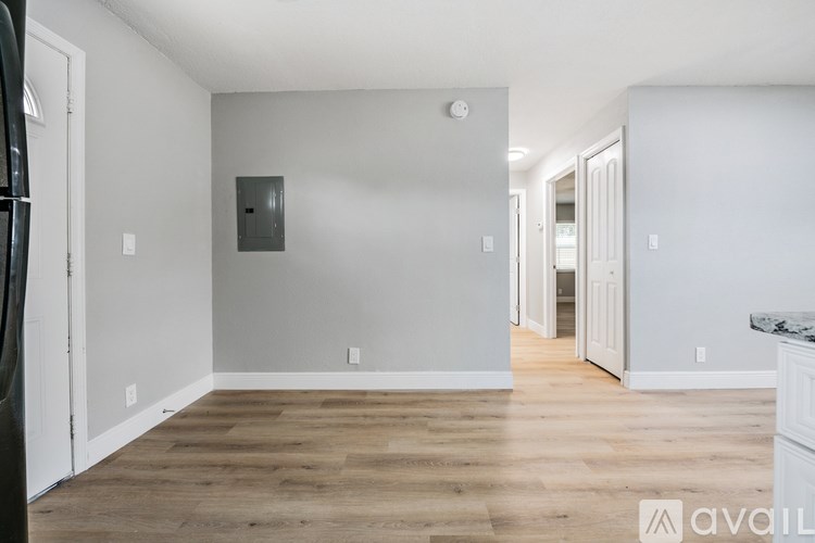 A room with wooden flooring and white walls.