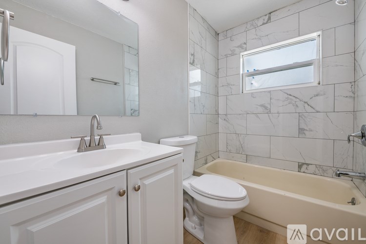 A white bathroom with a tub, toilet, and sink.