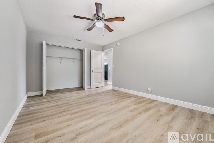 A room with a ceiling fan and wooden flooring.