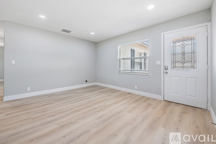 A room with a white door and a window with blinds.