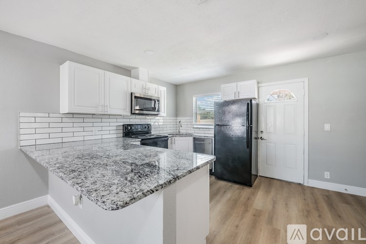 A kitchen with granite countertops and white cabinets.