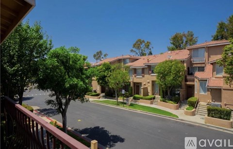 A row of houses with a tree in the foreground.