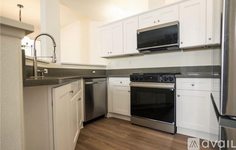 A kitchen with white cabinets and stainless steel appliances.