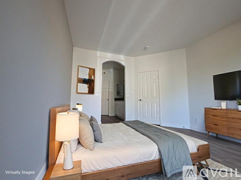 A bedroom with a bed, nightstand, and lamp.