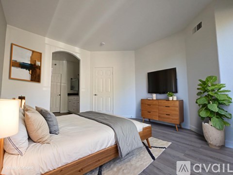 A bedroom with a bed, dresser, and mirror.