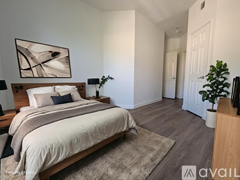 A bedroom with a large bed and a painting on the wall.