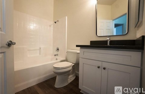 A white toilet sits in a bathroom next to a sink.