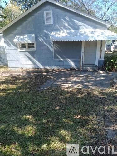 A small house with a grey roof and a white door.