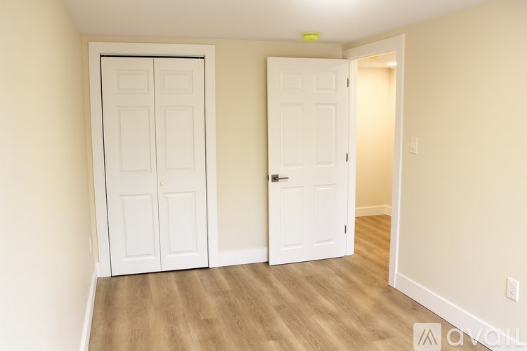 A room with two white doors and wooden flooring.