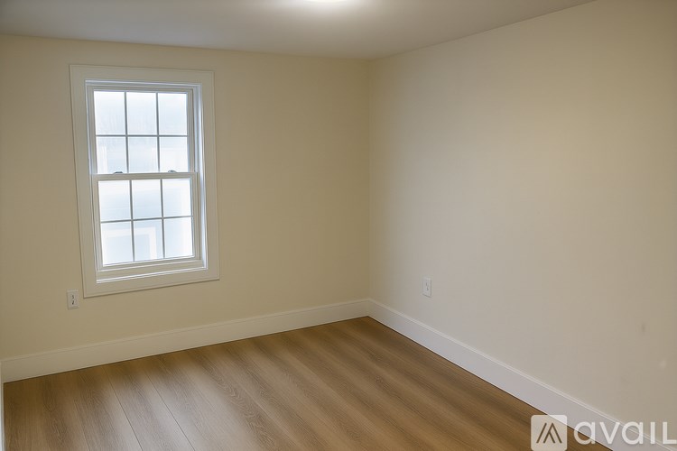 A room with a window and wooden flooring.