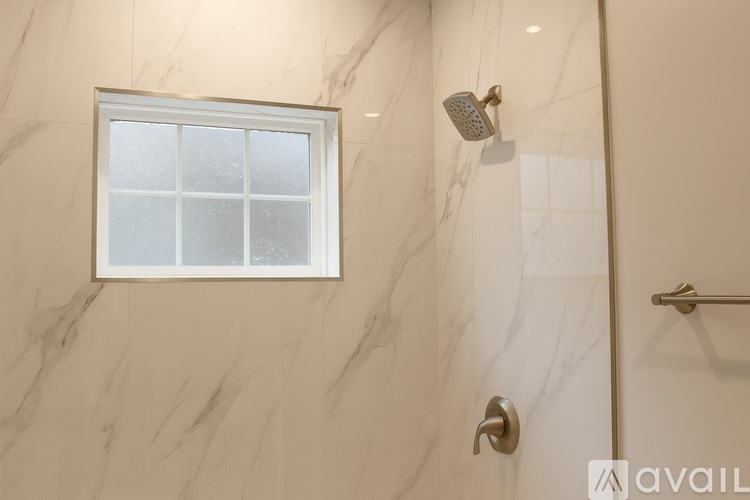 A bathroom with a marble wall and a window.